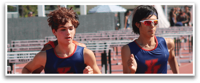 Two people running on a track. Description generated by AI