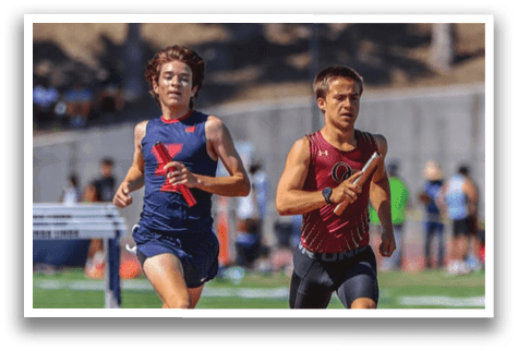 Two boys running on a track. Description generated by AI