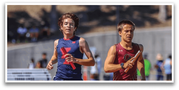 Two boys running on a track. Description generated by AI