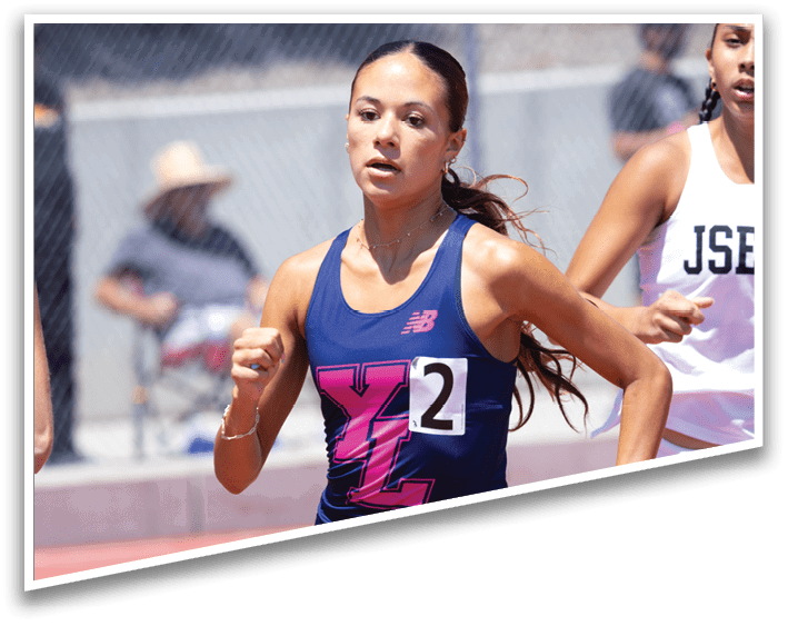 A woman running on a track with the number 21 on her shirt. Description generated by AI