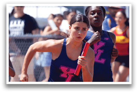 A girl running on a track with a pink and blue shirt. Description generated by AI
