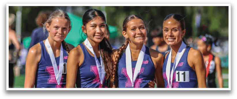 Four women wearing blue and pink uniforms. Description generated by AI