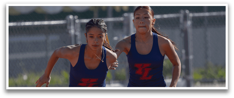 Two female runners are running on a track, one wearing a blue shirt and the other wearing a red shirt. AI generated content