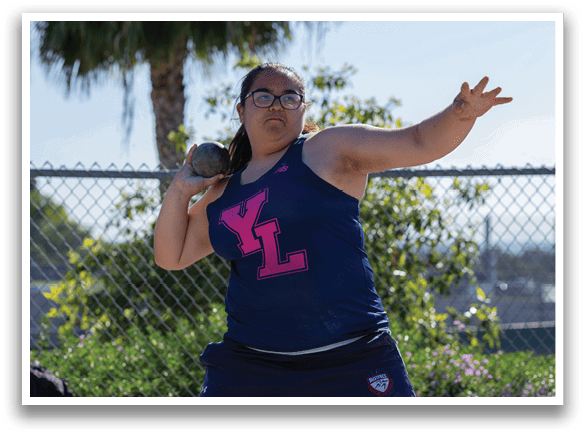 A woman wearing a blue shirt and shorts is throwing a baseball. AI generated content