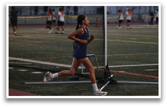 A woman is running on a track, wearing a blue and red outfit. AI generated content