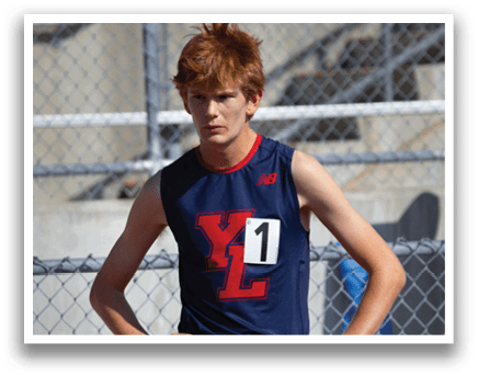 A young man wearing a blue and red track suit stands on a track. AI generated content