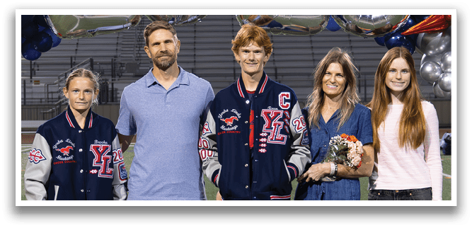 A group of people, including a man, woman, and two children, pose for a photo on a football field. AI generated content