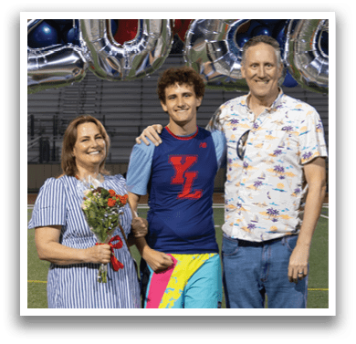 A man and woman stand on a football field in front of a banner that reads “2026." The man is wearing a blue shirt and holding a bouquet of flowers. AI generated content