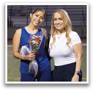 Two women standing on a field, one holding a trophy. AI generated content