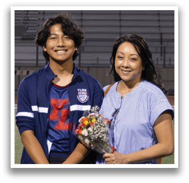 A man and a woman stand on a football field in front of a banner that reads “2026." AI generated content