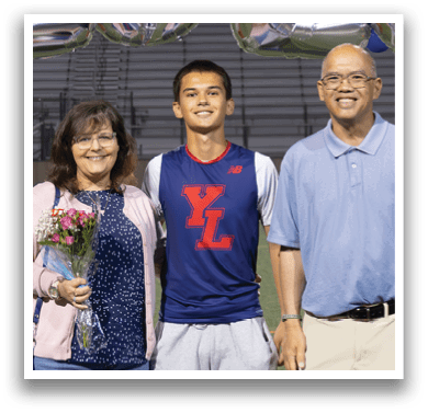 A man, woman, and boy pose for a photo in front of a banner that reads “2026." AI generated content
