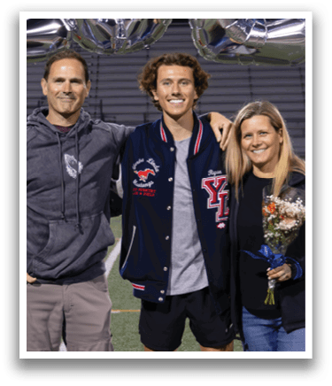 A man, woman, and child pose for a photo in front of a banner that reads “2026". AI generated content