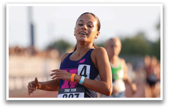 A woman wearing a blue and white shirt is running on a track. Description generated by AI