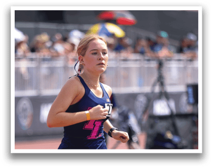 Two girls running on a track. Description generated by AI