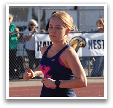 A woman running on a track. Description generated by AI
