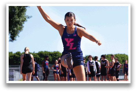 A woman is jumping in the air on a track. Description generated by AI