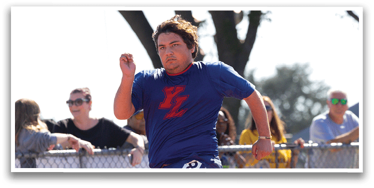 A man running on a track with a blue shirt and black shorts. Description generated by AI