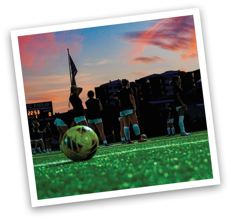 A group of girls are standing on a field with a soccer ball in the center. AI generated content