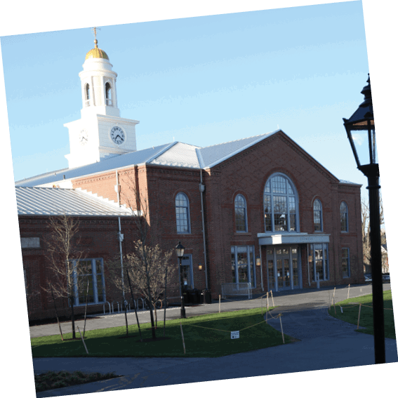 A bench is located in front of a building with a clock tower. AI generated content