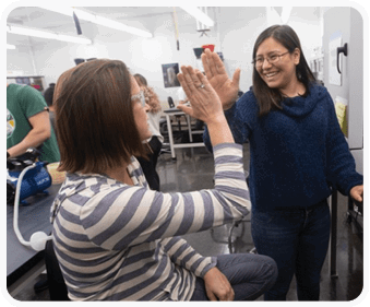 Two women are in a room, one sitting and the other standing. The standing woman is holding up her hand. AI generated content
