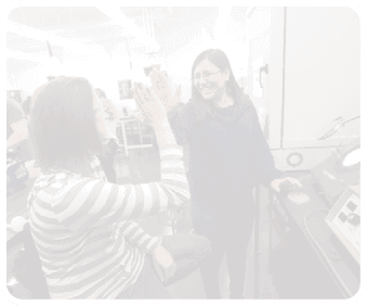 Two women are in a room, one sitting and the other standing. The standing woman is holding up her hand. AI generated content