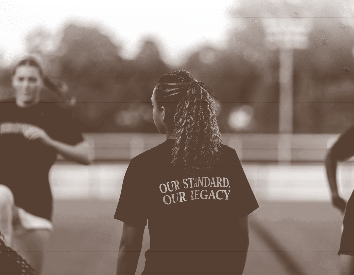 Three women wearing black shirts are standing on a field. AI generated content