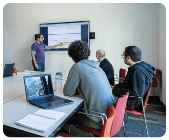 A group of people are sitting around a table, looking at a screen. AI generated content
