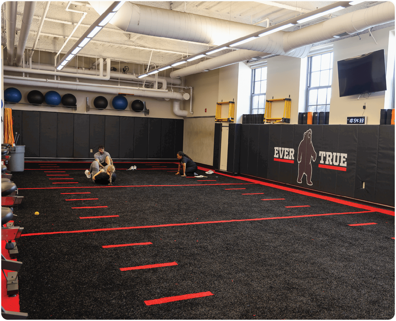 A man is kneeling on a mat in a gym, possibly doing a workout. AI generated content