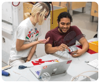 A man and a woman are working on a project together. The man is holding a kite while the woman is pointing at something. They are both smiling and appear to be enjoying the activity. AI generated content
