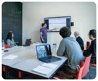 A group of people are sitting around a table, looking at a screen. AI generated content