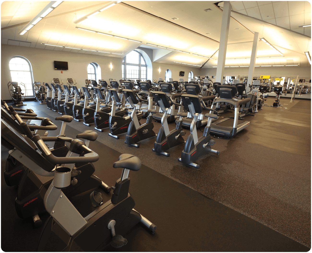 A gym with many exercise machines, including bikes and treadmills. AI generated content