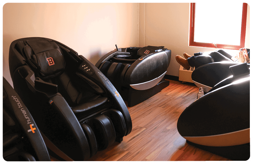 A room with several chairs and a couch, some of which are massage chairs. AI generated content