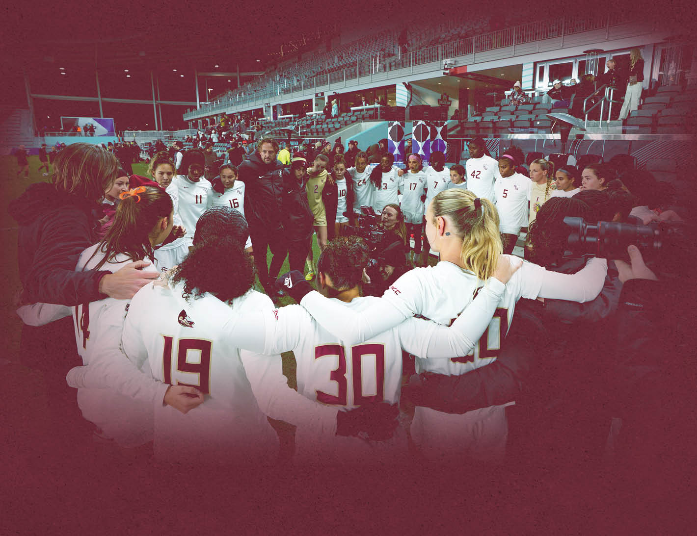 A group of people, including women, are huddled together on a field. AI generated content