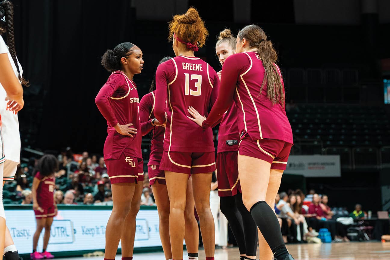 A group of women wearing red and white uniforms are standing on a basketball court. AI generated content