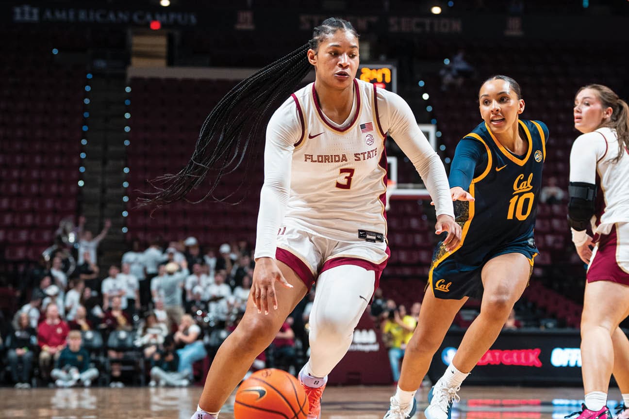 Two female basketball players on a court, one with a ball and the other trying to block her. AI generated content