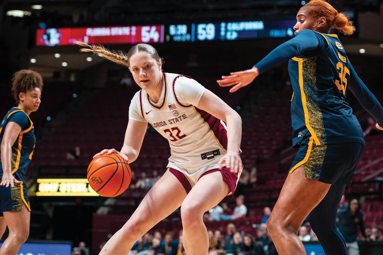 Two female basketball players on a court, one with a basketball in her hand and the other trying to block her. AI generated content