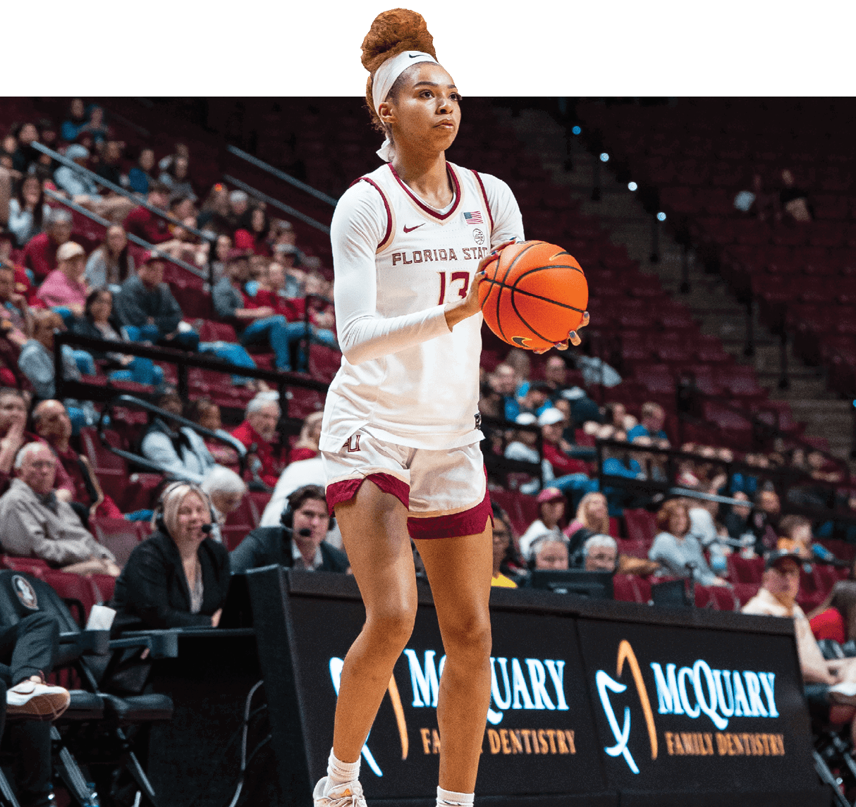A woman wearing a white shirt and shorts is holding a basketball. AI generated content