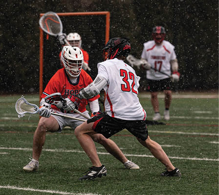 A group of people playing a game of lacrosse. Description generated by AI