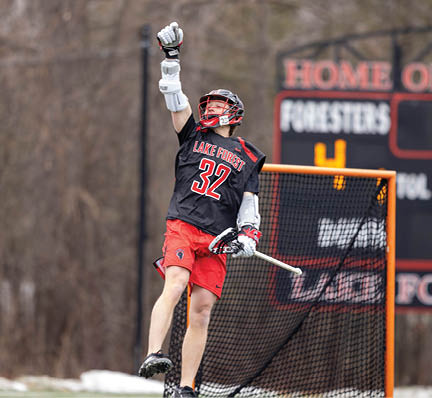 A man wearing a black jersey with the number 32 on it is jumping in the air. Description generated by AI
