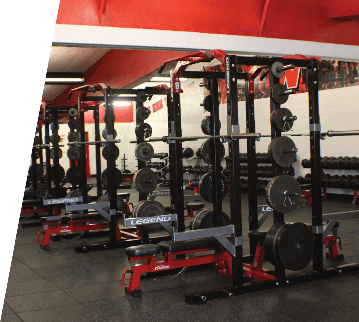 A gym with a row of black and red machines. AI generated content