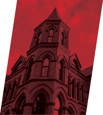 A tall brick building with a pointed roof and arched windows. AI generated content