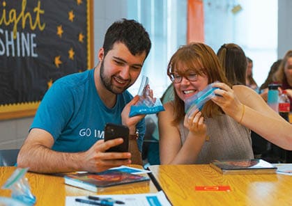 Two people are sitting at a table, looking at their cell phones. AI generated content