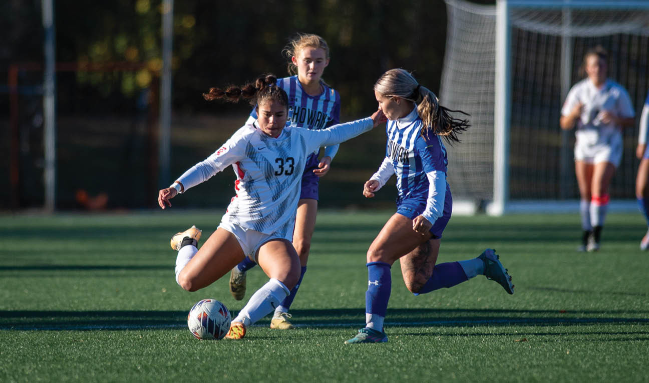 Two girls playing soccer on a field. AI generated content