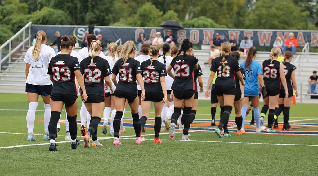 A group of female soccer players are walking across a field. AI generated content