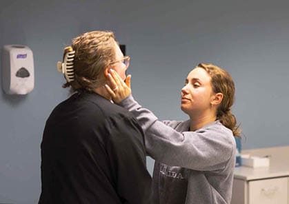 A woman is helping another woman with her hair in a room. AI generated content