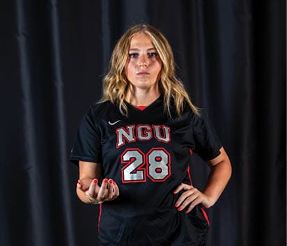 A woman in a black jersey with the number 28 on it is standing on a green surface. AI generated content