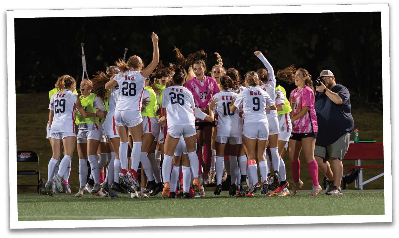 A group of women are celebrating on a field, with some of them wearing pink and white uniforms. They are hugging and cheering, with one woman holding a cell phone. AI generated content