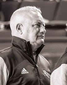 Two adults wearing Adidas jackets are standing close to each other, with one facing sideways and the other facing away. Description generated by AI