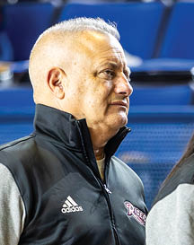 Two adults wearing Adidas jackets are standing close to each other, with one facing sideways and the other facing away. Description generated by AI