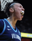 A person wearing a Villanova basketball jersey with the number 5 is celebrating on the court while another person in a UConn jersey is in the background. Description generated by AI
